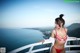 A woman in a red and white bikini standing on a balcony.