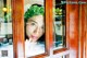 A woman looking out of a window at the camera.